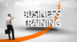 © ra2 studio - Rear view of a businessman standing in front of BUSINESS TRAINING inscription, successful business concept