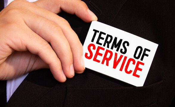 The businessman holds a business card with the text OF TERMS TO SERVICE.
