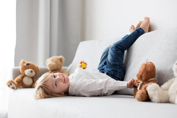 Poster - Cute child, lying in bed, reading book