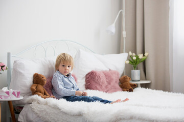 Canvas Print - Cute child, lying in bed, reading book