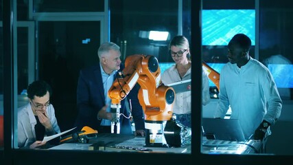 Wall Mural - international group of scientists observing a robotic arm in a modern laboratory.