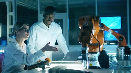 Wall Mural - two scientists are watching a functioning robotic arm. team of engineers working in modern innovativ