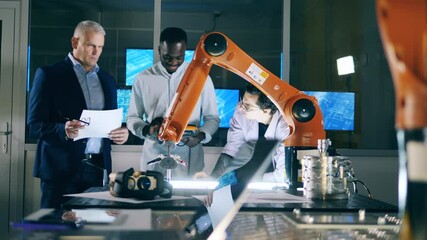 Wall Mural - group of male scientists are watching a robotic arm while drawing