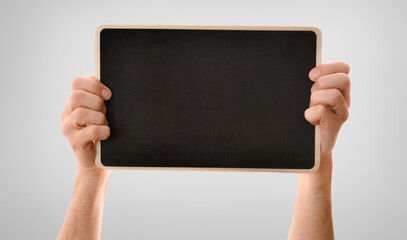 two hands gripping tightly blackboard isolated gray gradient background