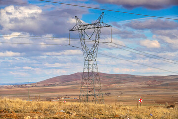 High voltage electric pole and transmission lines. High voltage grid tower with wire cable at distribution station.