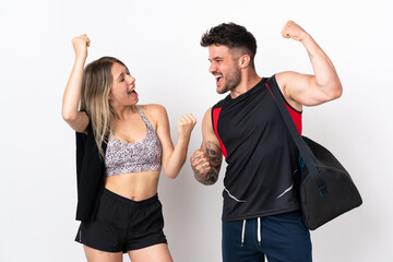 Young sport couple isolated on white background celebrating a victory in winner position