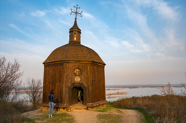 old wooden church on high hills near the wide river in spring