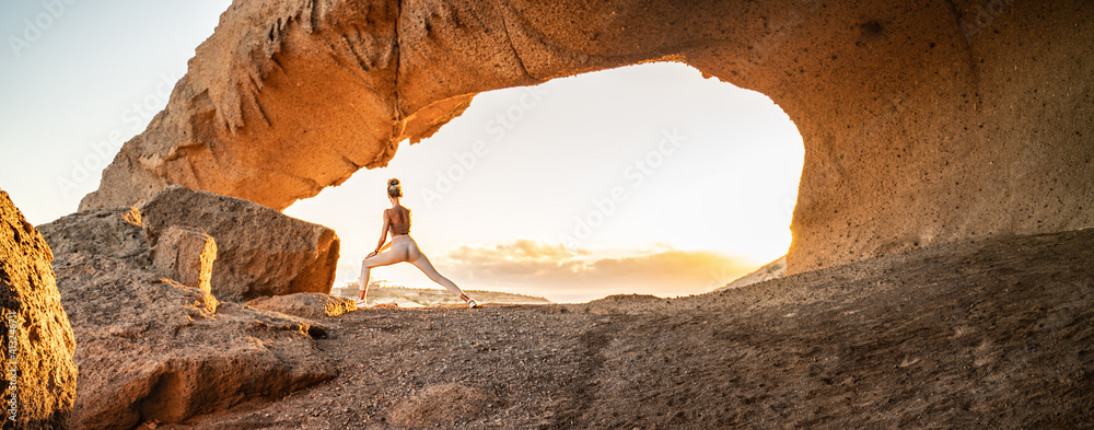 Woman doing yoga, stretching, meditating on the top of a mountain above clouds at sunrise. Zen, meditation, peace of mind concept. Travel. Beauty in nature. - obrazy, fototapety, plakaty 