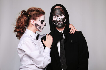 a girl and a man in Halloween makeup in the image of dead people with a black skull, wearing a black hoodie and a white shirt