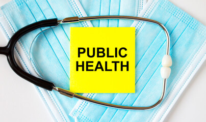 Yellow sticker with text Public Health lying on the masks and stethoscope