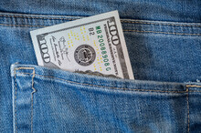 Pile Of One Hundred American Dollar Banknotes In The Back Jeans Pocket. Close Up One Hundred US Dollar As Symbol Of Poverty And Bankruptcy.