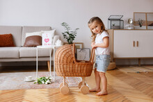 Little Girl With A Toy Stroller In The Living Room