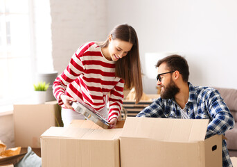 Wall Mural - Smiling couple unpacking carton boxes in new home