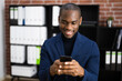 © Andrey Popov - African American Man Texting On Smartphone