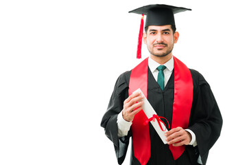 Handsome young man holding his university diploma