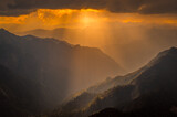 Fototapeta Do pokoju - Sunset over the mountains. Serene golden hues of sun rays at Himalayan snowscapes mountains, Parvati valley, Kasol, Himachal Pradesh, northern India.