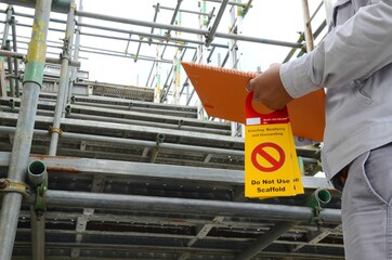 Scaffolding inspectors or supervisor are checking scaffolding by using checklists and tags are for hanging detailing labels on scaffolding in onshore oil and gas plant, chemicals plant or power plant