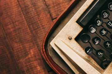 Fototapete - retro typewriter on wooden background and paper decoration texture