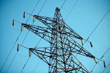 Power line against the blue sky. Hi-voltage electrical pylons