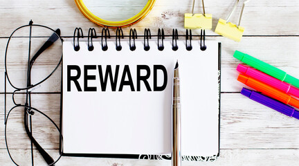 Poster - REWARD written in a notebook on white background with office tools