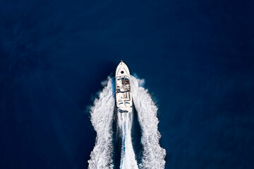 Wall Mural - aerial top down view to a speedboat driving over blue sea with copy space
