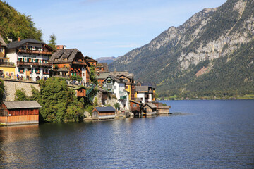 Wall Mural - Mesmerizing shot of coastline buildings withreflecting lake and mountains