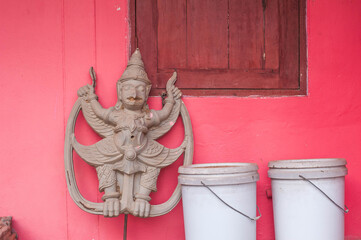 Buddhist Garuda sculpture with Pink background at Wat Phu noi temple , Naklang district Nong bualamphu province Thailand