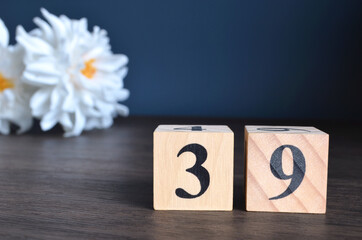 Wall Mural - Number 39, rating, award, Empty cover design in natural concept with a number cube and peony flower on wooden table for a background.