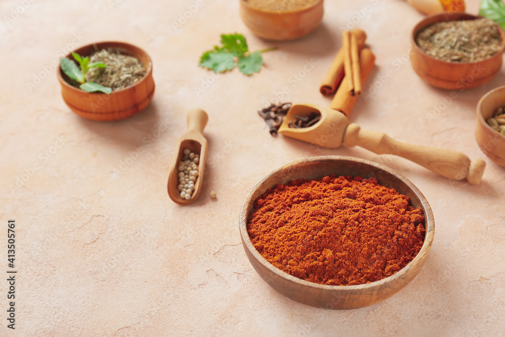 Bowls and scoops with different spices on color background