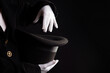 Hand gestures. illusionist holds a hat in his hands and shows magic and tricks. Black background