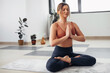 © likoper - Fit young woman practice yoga. Fitness female instructor doing yoga meditation indoors.
