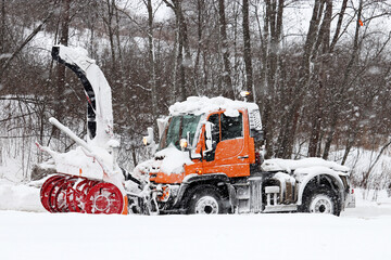 Wall Mural - Snow plow machine on a road, street cleaning in winter city during blizzard weather