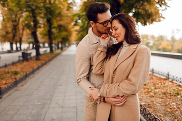 Wall Mural - Romantic moments. Happy beautiful couple in love fooling around and having fun in amazing autumn park.