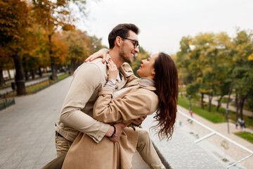 Outdoor  photo of happy young woman with her boyfriend enjoying date. Cold season.