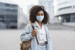 © kite_rin - Young woman wearing protective face mask in a city, Masked african student girl on a city street, Epidemic, pandemic, corona virus protection, healthy lifestyle, people concept