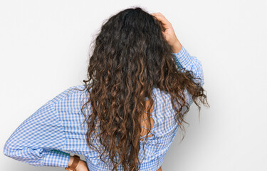 Young hispanic girl wearing casual clothes backwards thinking about doubt with hand on head