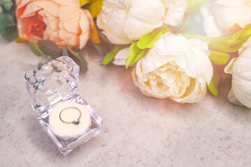 wedding ring in box with peony flowers.