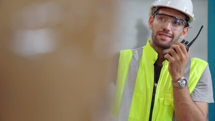 Wall Mural - Professional cargo worker talks on portable radio to contact another worker . Factory and warehouse communication concept .