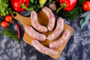 Sticker - Fresh raw sausage on wooden board, Raw barbecue sausages with spices and vegetables. Top view Freshly made raw breed butchers sausages. Free space