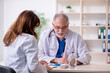 © Elnur - Old male doctor and his young female assistant in the clinic