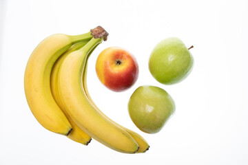 Banana with fresh red and green apples on white