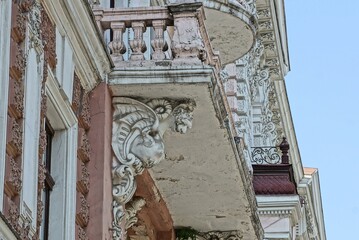 Sticker - part of the brown concrete wall of a historic building and a white balcony with sculpture