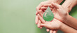 Hands holding paper cut green oil drop, CSR, alternative biofuel renewable green energy concept