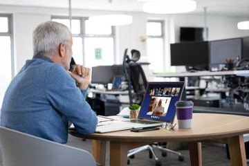 Poster - Caucasian man in office having video call with colleagues displayed on laptop screen