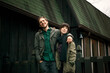 © Cavan Images - Smiling young couple standing with arms around against building