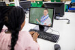 © vectorfusionart - Female student having a video call with female teacher on computer at school