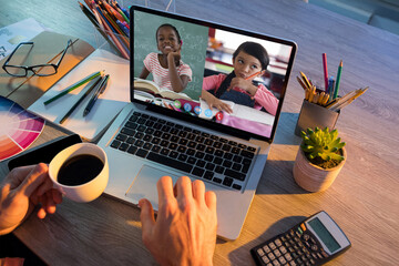 Sticker - Mid section of teacher having a video conference with two female students on laptop at school