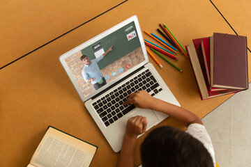 Poster - Overhead view of male student having a video call with male teacher on laptop at school