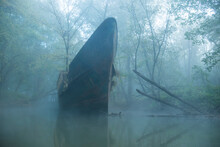 Abandoned Boat On River In Forest During Foggy Weather