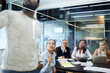 © Cavan Images - Multi-ethnic colleagues looking at entrepreneur giving presentation in meeting at board room